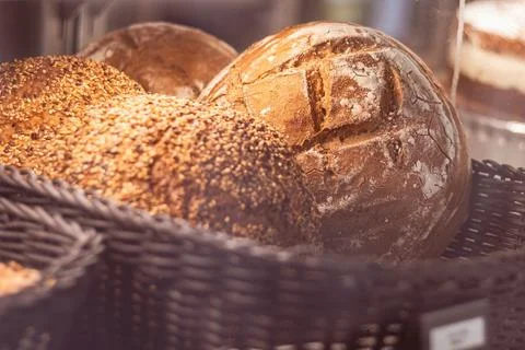 Warm artisan bread rolls in a rustic basket basking in morning light at a local Stock Photos