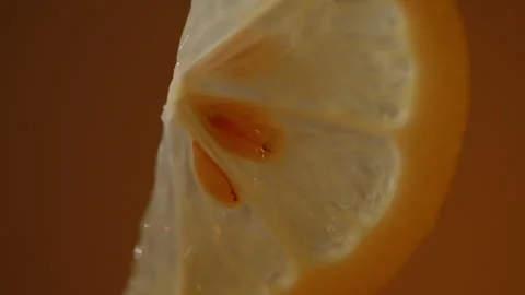Warm Backlit Lemon Slice With Translucent Citrus and Seeds Stock Footage 336464088