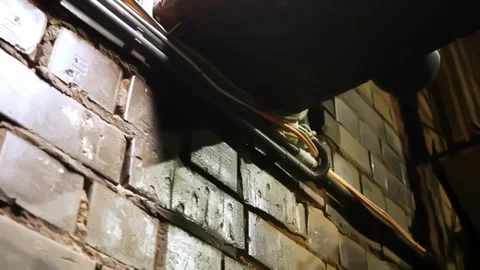 Warm backstage close-up of exposed electric cables and conduits running along a Stock Footage 334013779
