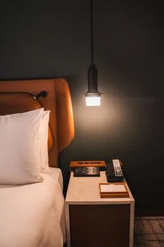 Warm bedside setting with leather headboard and pendant lamp Stock Photos