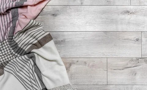 Warm blanket on the background of the laminate. Stock Photos