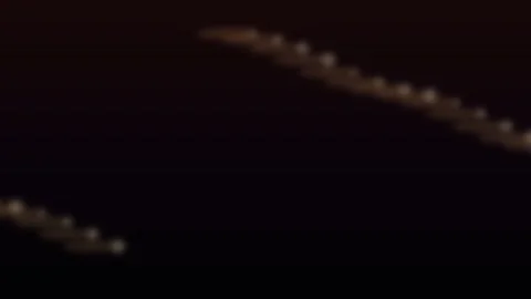Warm bokeh light trails moving across a dark background Stock Footage 336995445