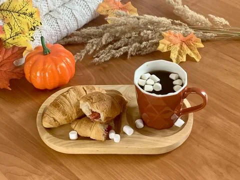 A warm breakfast setting features flaky croissants filled with fruit, Foto stock