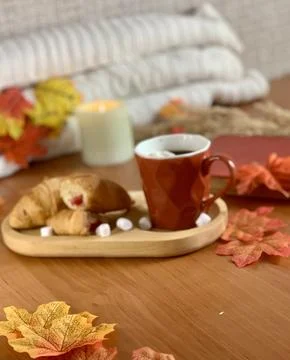 A warm breakfast setting features freshly baked croissants, a steaming cup of Stock Photos
