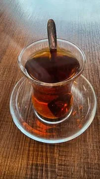 A Warm Brewed Tea presented elegantly in a Glass Cup resting on a Wooden Table 스톡 사진
