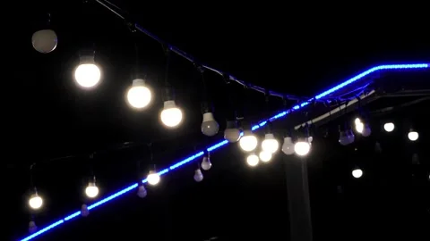 Warm Bulb String Lights with Blue LED Accent Glowing Against the Night Sky Stock Footage 321361631