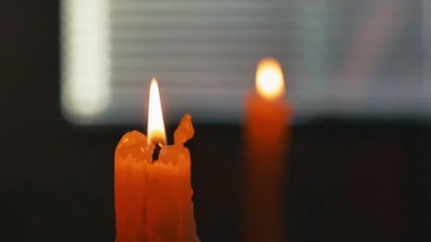 Warm candle flame burns softly indoors with shallow depth of field Stock Footage 344344361