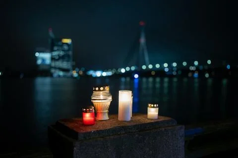 Warm candlelight placed on a stone surface overlooking the Riga city waterfront Stock Photos