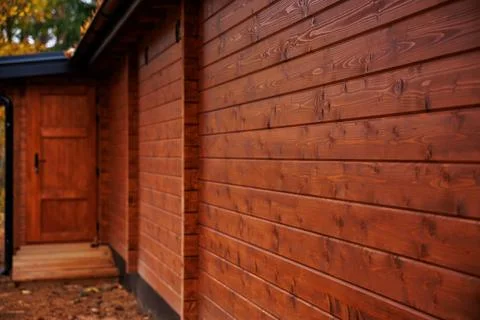Warm cedar siding and timber entryway with black metal hardware Stock Photos