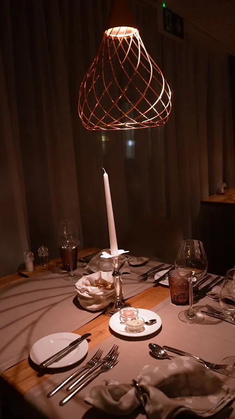 Warm chalet dining table under copper pendant with candlelight Video stock 331957648