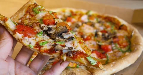 Warm cheesy pizza slice with melted mozzarella, tomato, mushrooms and pesto is Stock Footage 309048126