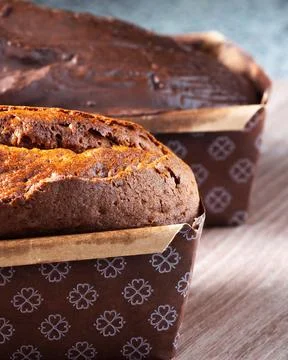 Warm chocolate loaf baked in patterned paper loaf pan 库存照片