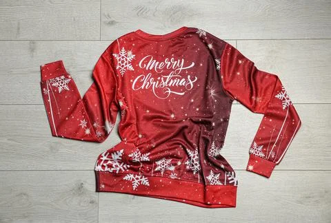 Warm Christmas sweater on wooden table, top view Stock Photos