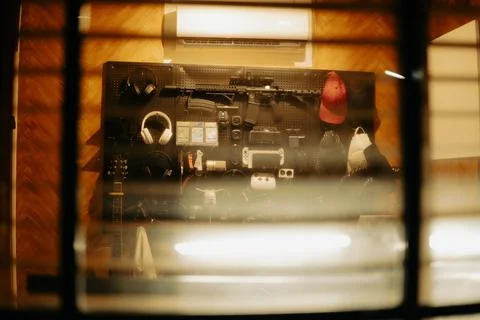 Warm Cinematic Desk Setup Viewed Through Window Blinds at Night Stock Photos