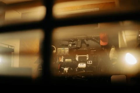 Warm Cinematic Desk Setup Viewed Through Window Blinds at Night Stock Photos