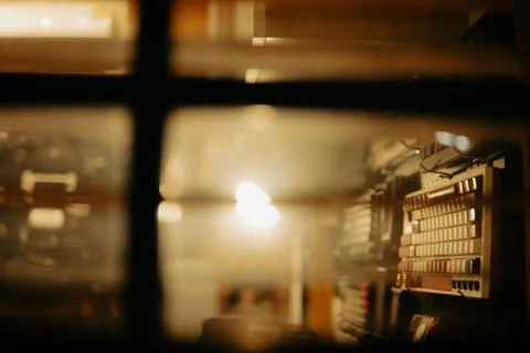 Warm Cinematic Desk Setup Viewed Through Window Blinds at Night Stock Photos