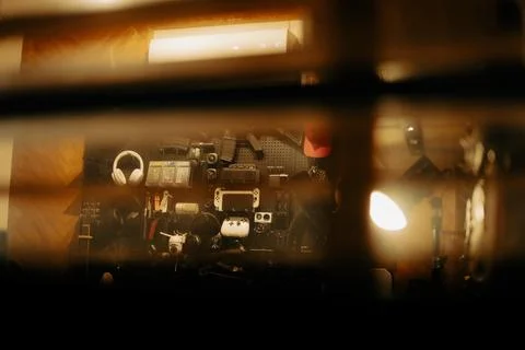 Warm Cinematic Desk Setup Viewed Through Window Blinds at Night Stock Photos