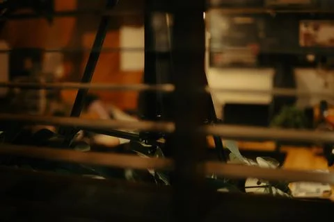 Warm Cinematic Desk Setup Viewed Through Window Blinds at Night Stock Photos