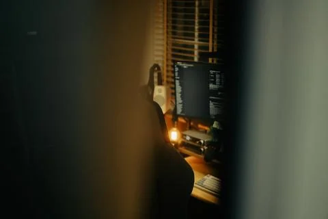 Warm Cinematic Desk Setup Viewed Through Window Blinds at Night Stock Photos