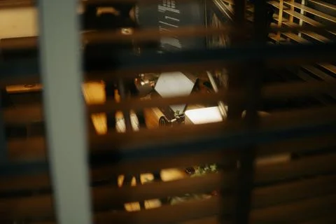 Warm Cinematic Desk Setup Viewed Through Window Blinds at Night Stock Photos