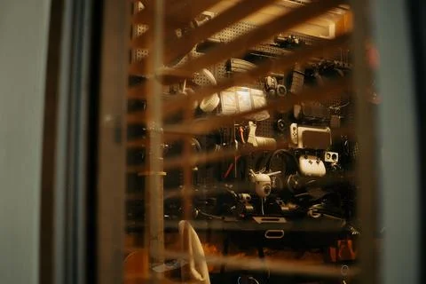 Warm Cinematic Desk Setup Viewed Through Window Blinds at Night Stock Photos