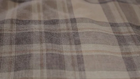 A warm cloth with a brownish checkered pattern forming squares. - Wide Shot Stock Footage 128358808