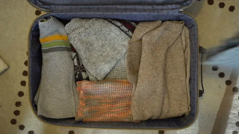 Warm clothes thrown in a suitcase 4K Stock Footage 103513416