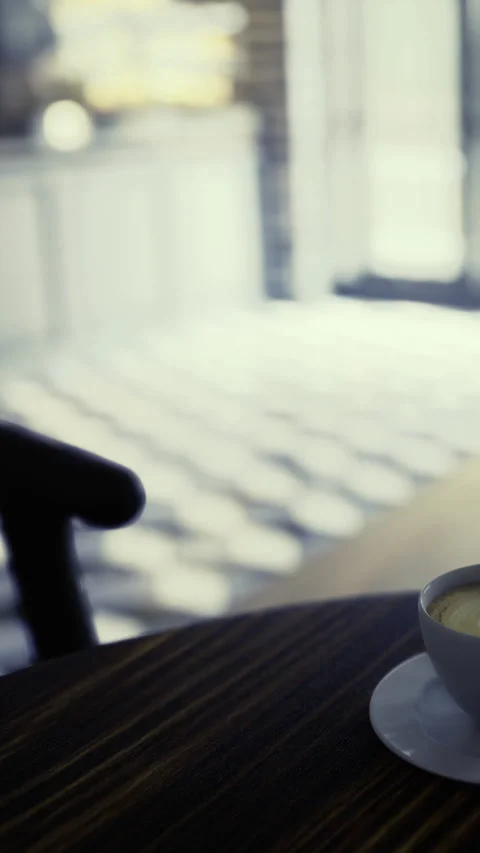 Warm coffee cup resting on a cozy table in a sunlit cafe nook Stock Footage 342461629