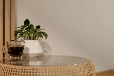Warm coffee cup on wicker table in minimalist room Illustrazione stock