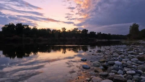 Warm Color Sunset Reflecting Over Calm Flowing River Stock Footage 328615689