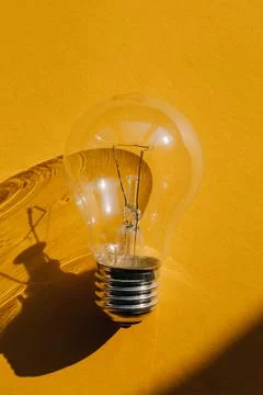 Warm colored and active bulb on a dark background. Power saving light bulb Фото