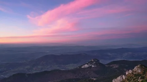 Warm colors of clouds at dusk in a rocky forest mountain landscape. Stock Footage 221016044