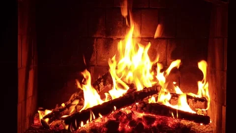 Warm cozy burning fire in a brick fireplace, close-up shot Stock Footage 303383411