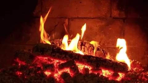 Warm cozy burning fire in a brick fireplace, close-up shot Stock Footage 303602943