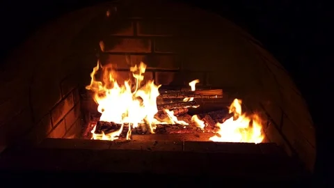 Warm cozy burning fire in a brick fireplace, close-up shot Stock Footage 313507389