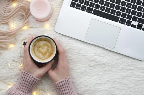 Warm cozy winter workspace background. Flat lay. Girl holding a cup of coffee on Stock Photos