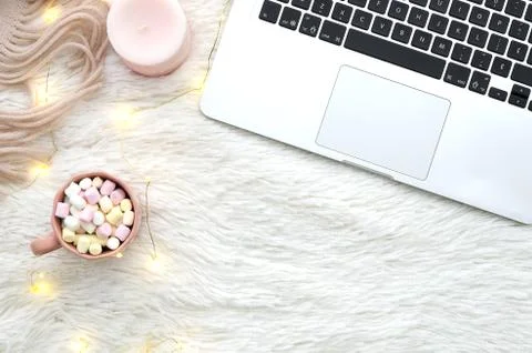 Warm cozy winter workspace background. Sweet cocoa with marshmallow on fur Stock Photos