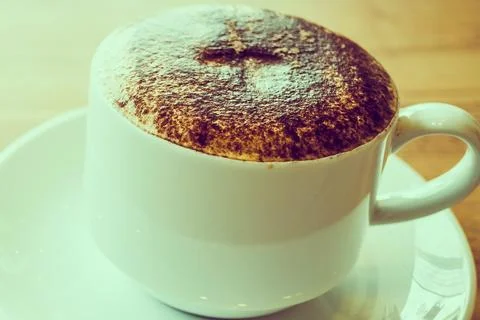 Warm cup of coffee with chocolate dusting on a saucer Stock Photos
