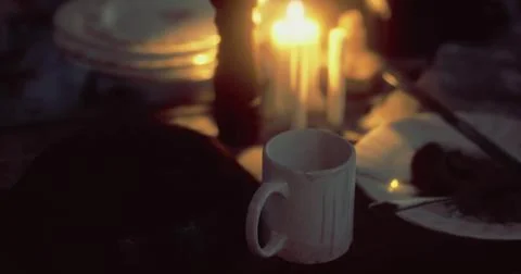 Warm cup resting on table surrounded by soft candlelight at dusk Stock Illustration