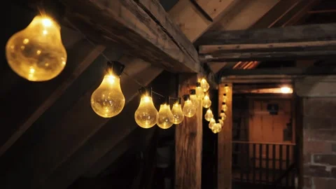 Warm Decorative String Lights Hanging in Rustic Wooden Attic Interior at Night Video stock 310212214