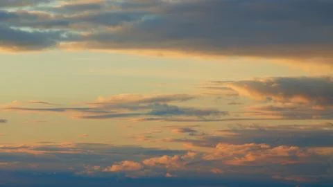 Warm dramatic clouds in red tones. Sunset cloud shot over clouds. Timelapse. Stock Photos