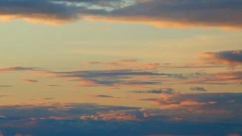 Warm dramatic clouds in red tones. Sunset cloud shot over clouds. Timelapse. Stock Photos