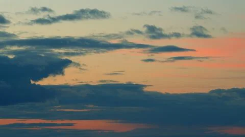 Warm dramatic clouds in red tones. Sunset cloud shot over clouds. Timelapse. Stock Photos