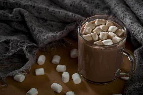 Warm drink with marshmallows placed on a textured fabric with scattered mar.. Stock Photos