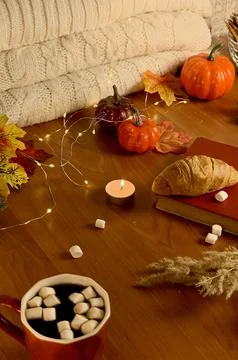 A warm drink with marshmallows sits on a table surrounded by fall decorations Foto stock