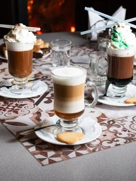 Warm drinks sit on a patterned tablecloth Фото