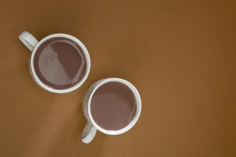 Warm drinks in white cups on a simple brown surface during afternoon coffee.. Stock Photos