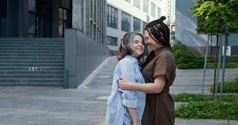Warm embrace between friends outside modern urban buildings Stock Footage 301237975