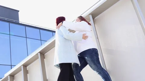 Warm embrace between friends on a rooftop during a sunny day in the city Stock Footage 295274017