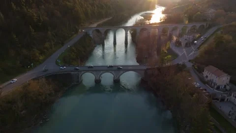 Warm evening light hits bridge and passing cars in Sisteron Stock Footage 307313925